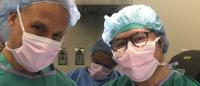 Alex Vu, wearing scrubs and a surgical mask, poses for a photo